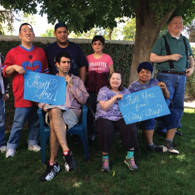 developmentally disabled clients on a picnic holding thank you signs
